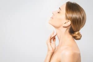 Woman demonstrates neck profile to represent non-surgical lifting options.