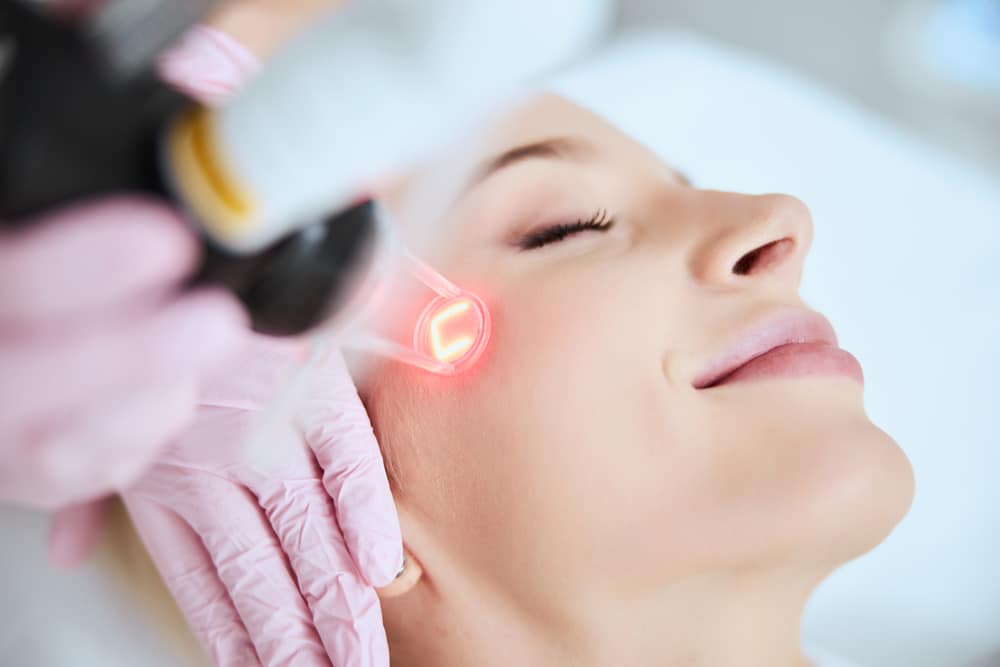 Woman undergoing gentle laser skin treatment to reduce wrinkles and enhance skin firmness.