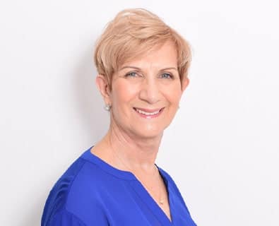 Middle-aged woman after facelift surgery performed by Miami facelift expert, Dr. Bustillo.