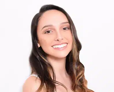 Happy young woman after rhinoplasty surgery performed by Dr. Bustillo in Miami.