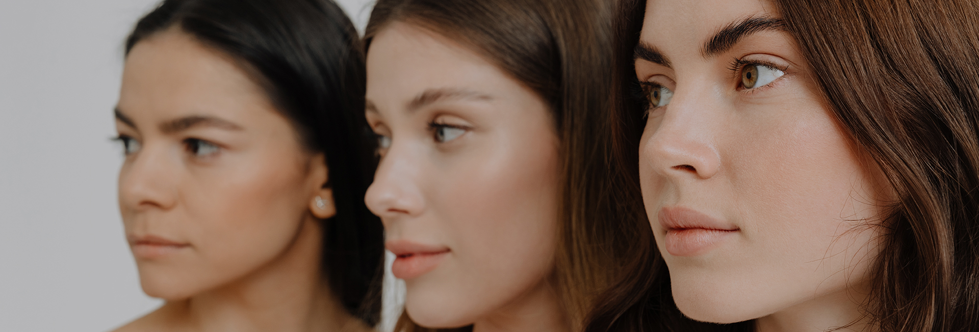Side profiles of three women showcasing natural nasal aesthetics, representing different rhinoplasty considerations.