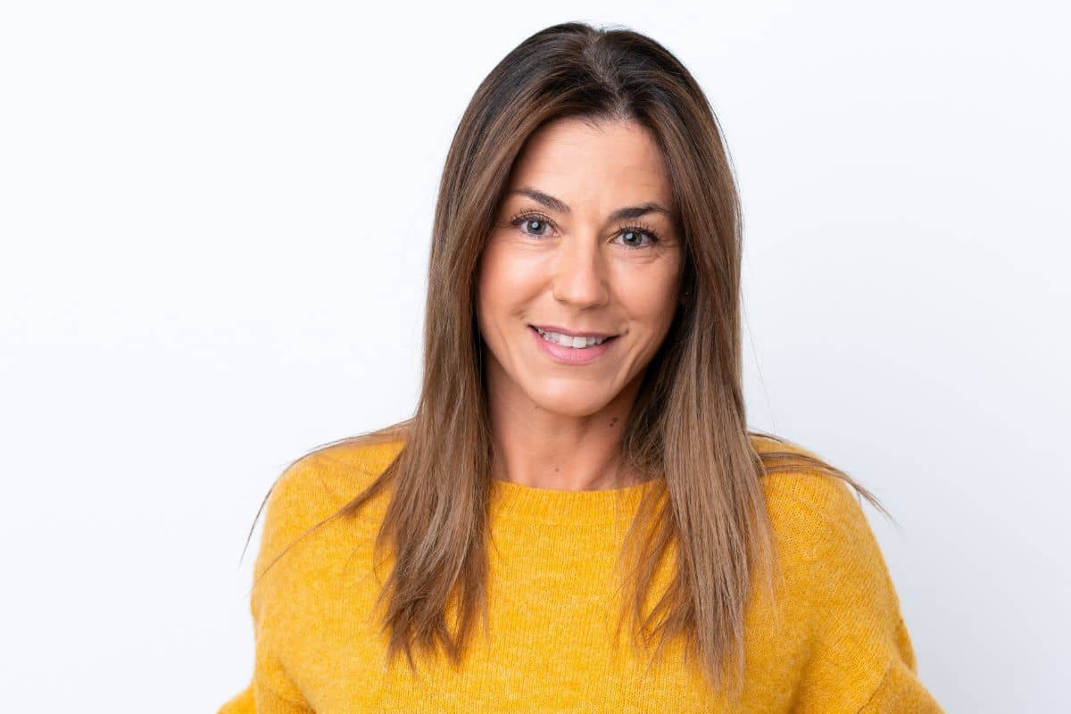 Middle-aged woman smiling confidently after deep plane facelift with natural, youthful facial rejuvenation results.